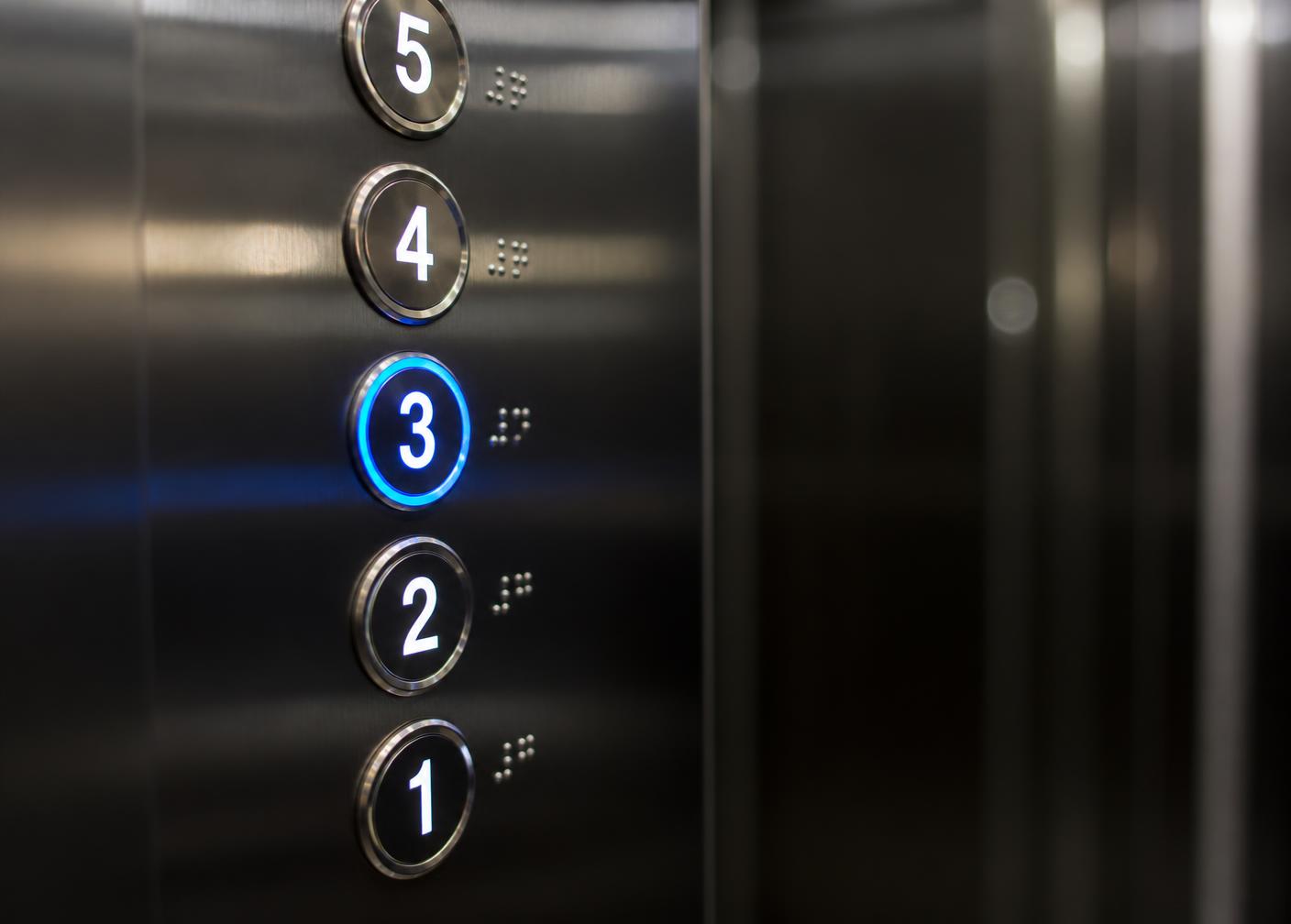 Close-up of a modern illuminated elevator control panel